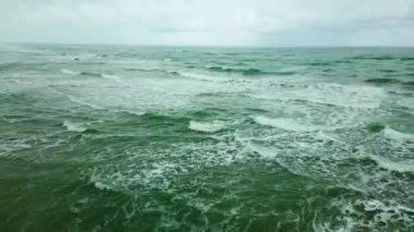 Dalgalar kıyıdan denize doğru uçuyor sonbaharda alçaktan, bulutlu bir günde Hazar Denizi 'ndeki bir dronda.
