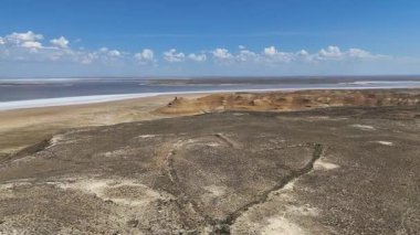 Ustyurt plato yüzeyine oyulmuş kalp benzeri ya da ok başlıklı geniş bir yapı, bozkır, görünür tepe ve uzaktaki depresyonla çevrili.