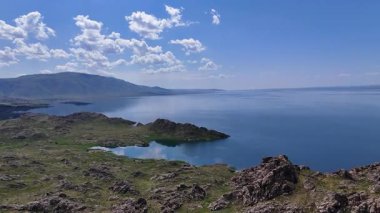 Uçurumlar ve uzak dağlarla çevrili mavi bir gölün insansız hava aracı manzarası, gün ışığında Bukhtarma Barajı, Doğu Kazakistan 'da çekildi. Fiyortlar, 4k, 30fps
