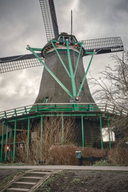 Yağmurlu bir günde, Zaanse Schans 'ta, bulutlu bir gökyüzünün altında çalışan De Bonte Hen petrol fabrikasının yakın çekimi.