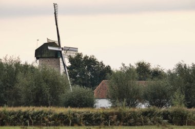 Hollanda 'daki' De Kilsdonkse Molen 'adlı imalathane manzarası Heeswijk-Dinther' de birleşik su ve rüzgar güdümlü bir değirmen olan 'Watervluchtmolen' olarak adlandırılır. 2009 'da yeniden inşa edildi..