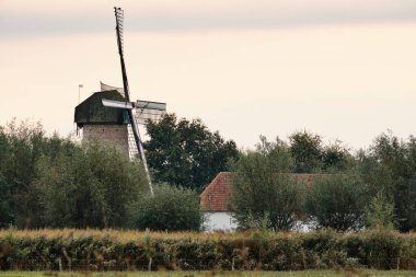 Picturesque scene of Dutch mill named 'De Kilsdonkse Molen'  is a so called 'Watervluchtmolen', a combined water and wind driven mill in Heeswijk-Dinther. It was reconstructed in 2009. clipart