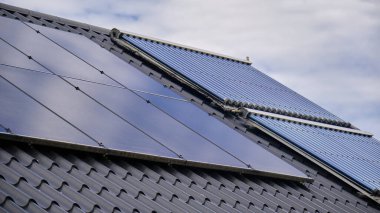 Yerleşim yerlerinin çatısına kurulmuş güneş panelleri, yenilenebilir enerjinin modern yaşama entegrasyonunu gösteriyor. Gündelik ortamlarda sürdürülebilir enerji çözümlerinin bir gösterimi