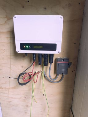 Hollanda 'daki bir eve bakım anahtarı ve topraklama ile birlikte ahşap bir panele küçük bir güneş dönüştürücü yerleştiriliyor..