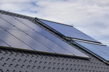 Yerleşim yerlerinin çatısına kurulmuş güneş panelleri, yenilenebilir enerjinin modern yaşama entegrasyonunu gösteriyor. Gündelik ortamlarda sürdürülebilir enerji çözümlerinin bir gösterimi