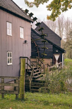 Serene view of historic watermills in Opwetten, Netherlands, surrounded by a peaceful natural landscape and rich cultural heritage. clipart