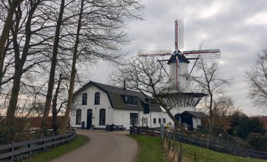 Hollanda, Deil 'deki tarihi yel değirmeni De Vlinder, çevresi yeşilliklerle çevrili, sergilenen Hollanda mirası, mimarisi ve sakin kırsal manzarası.