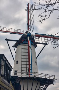 The historic windmill De Vlinder in Deil, Netherlands, surrounded by greenery, showcasing Dutch heritage, architecture, and a serene rural landscape. clipart