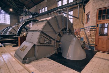 Lemmer, Netherlands - January 5, 2024: View of the Woudagemaal's historic interior featuring riveted steel steam engines in a beautifully preserved industrial setting. clipart