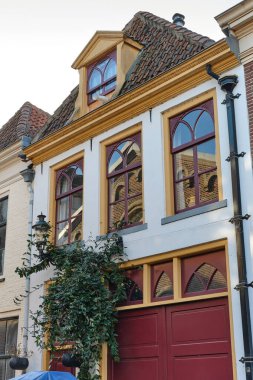 December 5, 2024 - Kampen/Netherlands: A small charming historic facade in Kampen, Netherlands, featuring masonry details typical for 20th century and a modern garbage bin named Kliko. clipart