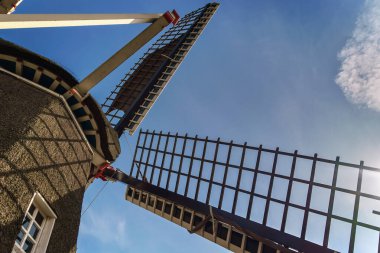 12 Mart 2022 - Hollanda Emmercompcuum: Kırsal alanda açık mavi bir gökyüzünün altında sazdan yapılmış bir çatısı olan tarihi yel değirmeni Grenszicht 'e yakından bakın.