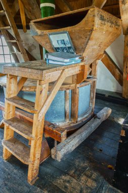 March 12, 2022 - Emmercompascuum, Netherlands: A historic wind powered mill stone inside Windmill Grenszicht, featuring wooden contruction, beams, gear and other milling equipment. clipart