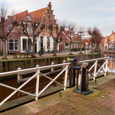 Hasselt, Hollanda: Geleneksel Hollanda evleri, budanmış ağaçlar ve bir kış günü tarihi atık su mekanizması bulunan manzara kanalı.