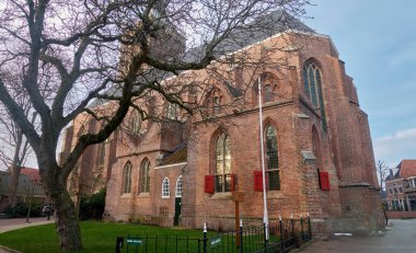 18 Aralık 2019 - Hollanda, Hasselt: Hollanda 'da büyük kemerli pencereleri, kırmızı panjurları ve Hollanda şehrinde bir tuğla cephesi olan tarihi Sint-Stephanuskerk Mağarası.
