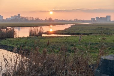 Eski Wessanen un fabrikası ve günbatımında su yansıması ile Brokking yem değirmeninin yer aldığı Schaalsmeerpolder 'ın Wormerveer' e olan açılışına bakın..