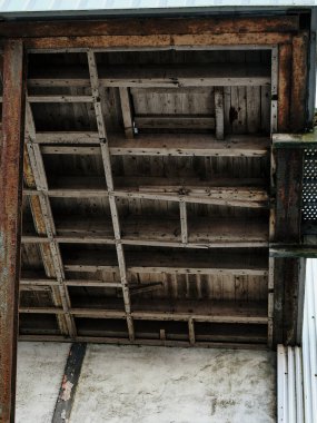 Çelik asansörlü tarihi bir tahıl ambarı, yıpranmış beton detaylar, ahşap tavan, endüstriyel bozulma ve terk edilmişlik sergiliyor..