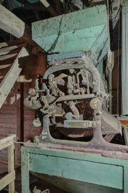 12 Mart 2025 - Hoya-Almanya: Tarihi bir su değirmeninde eski tahıl kütleçekimi ölçeği, paslanmış metal parçalarıyla kaplı, toz ve örümcek ağlarıyla kaplı,.