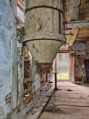 12 Mart 2025 - Hoya-Almanya: Eski un karıştırıcısı, ahşap kirişler, tuğla duvarlar ve terk edilmiş tarihi bir su değirmeninin içinde yıpranmış alçı.