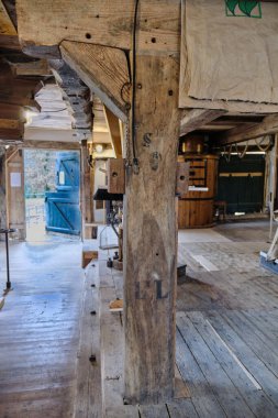 16 Mart 2025 - Neubruchhausen-Almanya: Ahşap direkli, kirişli ve birçok karaktere sahip geleneksel tarihi bir su değirmeni iç görünümü.