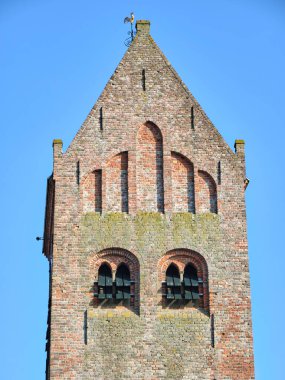 10 Mart 2025 - Grou-Hollanda: Grou, Friesland 'daki tarihi kilisenin eski çan kulesine bakın, tuğla bir yapı, eyer çatısı, kemerli pencereler ve kayrak bir çatısı var..