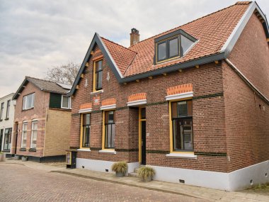 21 Nisan 2025 - Puttershoek-Hollanda: 1912 'den kalma detaylı tuğla ve Puttershoek' te sessiz bir caddedeki gable çatısı olan geleneksel Hollanda hendek evi.