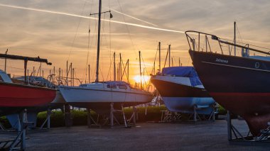 30 Nisan 2025 - Stad aan 't Haringvliet-Hollanda: Tekne sezonu başlamadan önce birkaç yelkenli tekne ve yatın bulunduğu Atlantika marinasında gün doğumu.