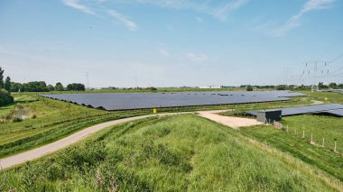 Hollanda: Hollanda enerji geçişi burada hem eski hem de yeni yüksek voltaj hatları ve yakınlardaki demiryolu hatlarıyla çevrili güneş parkları ile görülebilir.