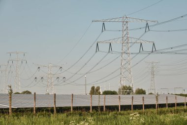 Yerseke-Hollanda: Hollanda enerji geçişi burada hem eski hem de yeni yüksek voltaj hatları ve yakınlardaki bir demiryolu hattı tarafından çevrelenmiş güneş parklarıyla görülebilir.