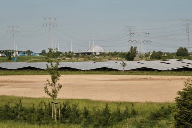 Zeeland-Hollanda: Hollanda enerji geçişi burada hem eski hem de yeni yüksek voltaj hatları ve yakınlardaki bir demiryolu hattı tarafından çevrelenmiş güneş parklarıyla görülebilir.