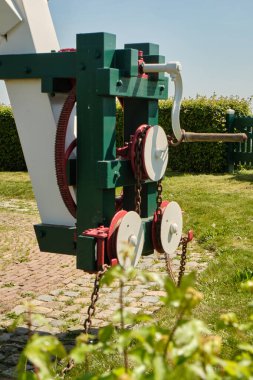 Sint-Filipsland-Hollanda: Güneşli bir bahar gününde açık mavi gökyüzünün altında yeşilliklerle çevrili Windmill De Hoop sarma teçhizatına yakın.