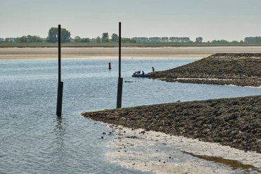 30 Nisan 2025 - Sint-Philipsland-Hollanda dalgaları gelgit limanında bir baba ve oğullarının kıyı şeridi boyunca küçük bir tekne hazırladıkları çamurlu düzlükleri ve istiridye kaplı kıyıları ortaya çıkardı..