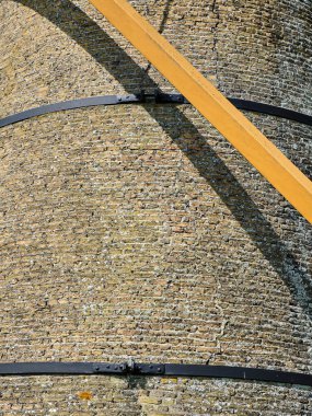 25 Nisan 2025 - Oostvoorne-Hollanda: Geleneksel Hollanda yel değirmeni bantları Oostvoornes Molen ve sarı kirişli tuğla kule.