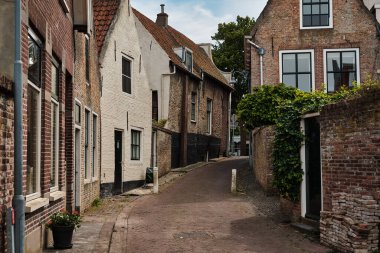 26 Mayıs 2025 - Zierikzee-Hollanda: Hollanda 'nın Schouwen-Duithe adasındaki Zierikzee kasabasında tarihi tuğla ve alçı evlerle kaplı dar bir ortaçağ geçidi.