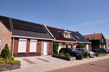 30 Nisan 2025 - Hollanda-Sint-Annaland-Hollanda: Hollanda güneş enerjisi sübvansiyon programının başarısını gösteren, çeşitli güneş paneli ayarlarına sahip sahipsiz evlerin sıralanması.