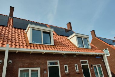 1 Haziran 2025 - Middelburg-Hollanda: Tipik bir 1930 sosyal konut bloğu, birçok ev ve yeni yatakhanelerde tekrarlanan güneş panelleri ile, ev halkına daha ucuz enerji faturaları sunan.