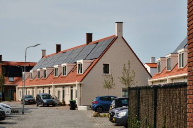 1 Haziran 2025 - Middelburg-Hollanda: Şehirde yenilenen sosyal konut bloğu, bir kooperatifin sahip olduğu birçok evde tekrarlanan güneş panelleri ile birlikte, ev halkı için daha az enerjili daha iyi bir izolasyon sunuyor..