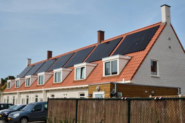 1 Haziran 2025 - Middelburg-Hollanda: Şehirde yenilenen sosyal konut bloğu, bir kooperatifin sahip olduğu birçok evde tekrarlanan güneş panelleri ile birlikte, ev halkı için daha az enerjili daha iyi bir izolasyon sunuyor..