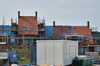 31 Mayıs 2025 - Middelburg-Hollanda: Yenileme çalışmaları devam eden sosyal konut projesi, Hollanda 'nın bir banliyösündeki bir inşaat sahasına yeni çatı fayansları döşeniyor.