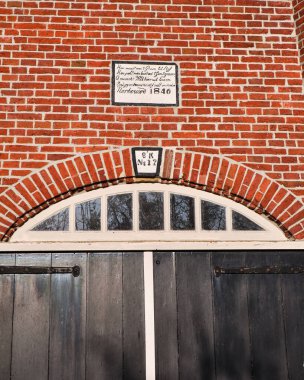9 Mart 2025 - Pieterburen-Hollanda: 1840 Pieterburen 'de bulunan tarihi Hollanda yel değirmeni De Vier Winden, dört yelkenli ve sahneli bir kule değirmeni, açık mavi gökyüzü altında güneş ışığında duruyor.