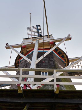 9 Mart 2025 - Pieterburen-Hollanda: 1840 Pieterburen 'de bulunan tarihi Hollanda yel değirmeni De Vier Winden, dört yelkenli ve sahneli bir kule değirmeni, açık mavi gökyüzü altında güneş ışığında duruyor.