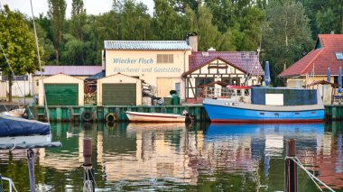 26 Haziran 2025 - Greifswald-Almanya: Wieck 'teki tarihi Ryck limanı, canlı balıkçı tekneleri ve deniz ürünleri lokantalarının evi, Greifswald' ın sahil cazibesinin özünü yakalıyor..