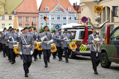 28 Haziran 2025 - Bundeswehr askeri bandosu eski pazar meydanından yürüdü, kadın kondüktör sol, standart hamiline ön sağ, Feldjaeger van ve pastel binalar arkada.