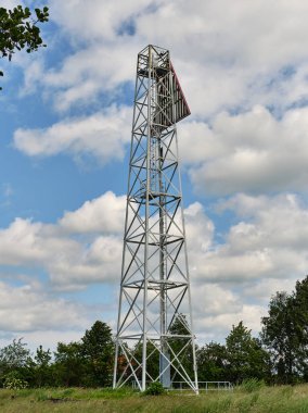 Kamminke-Almanya: Yeşil bitki örtüsü ve ağaçlarla çevrili Alman Polonya 'nın Kullanım Adası sınırındaki gemi navigasyonu için büyük çelik üçgen işaret feneri.