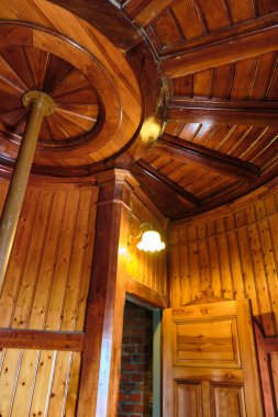 10 Temmuz 2025 - Putgarten-Almanya: Parlak ahşap duvarları ve tavanı olan tarihi deniz feneri bekleme odası, sıcak ışık ve klasik ayrıntılar.