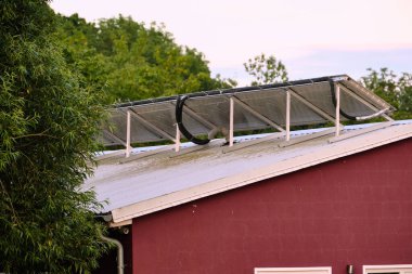 16 Temmuz 2025 Klockenhagen - Almanya: Güneş panelleri açık hava müzesindeki tarihi bir çiftlik evinin çatısını ve maskesini kaplayarak, maksimum yenilenebilir enerji kullanımını gösteriyor.