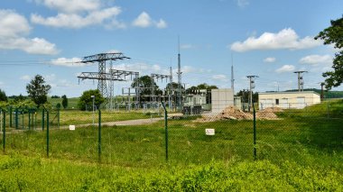 11 Haziran 2025 Woldegk - Almanya: Muehlencafe 'nin dışında paslı bir sabit motor sergileniyor, tarihi bir yel değirmeninin yanında yeşil bir bahçe ortamında..