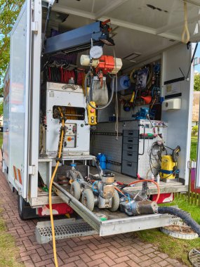 14 Temmuz 2025 - Klockenhagen-Almanya: Bir servis kamyonuna arkadan bakıldığında, sürgülü rafta, hortumlarda, aletlerde ve bakım için genel bir kaldırma sisteminde kanalizasyon temizleme robotları görülüyor.