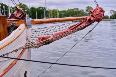 Lauterbach Limanı, Almanya 'ya demirli yelkenli yelkenli ve beyaz ahşap bir yelkenlinin yayı ve yelkenli kuşağının yakın çekimi.
