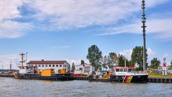 18 Haziran 2025; Karlshagen, Almanya: Alman Sahil Güvenlik, OIE ve Gormitz 'in iki atölyesi, Karlshagen' deki liman başı deposunda demirli, arka planda buidlings ve telsiz direği ile birlikte.