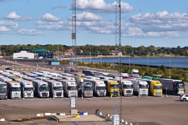 Trelleborg, İsveç; 23 Eylül 2025: Denizcilik yük lojistiği ve uluslararası taşımacılığı gösteren TT-Line feribot terminalinde kargo römorkları ve kamyonlar dizildi.